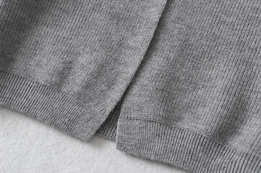 Stylish knitwear vest in a classic black or neutral colour, featuring a V-neck collar and long sleeves for a polished, versatile look.