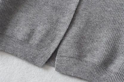 Stylish knitwear vest in a classic black or neutral colour, featuring a V-neck collar and long sleeves for a polished, versatile look.