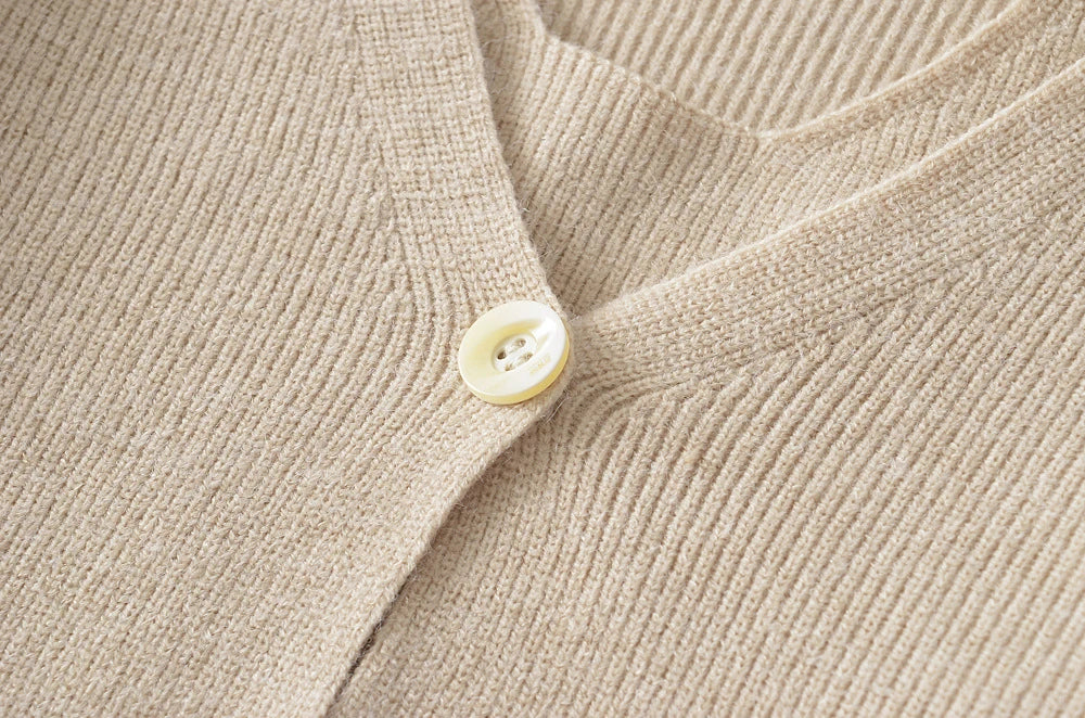 Stylish knitwear vest in a classic black or neutral colour, featuring a V-neck collar and long sleeves for a polished, versatile look.