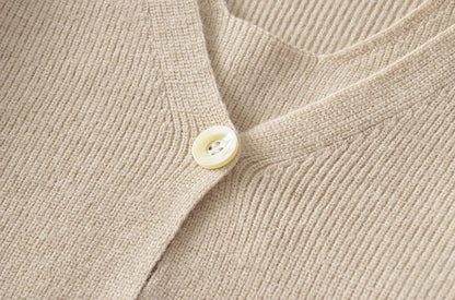 Stylish knitwear vest in a classic black or neutral colour, featuring a V-neck collar and long sleeves for a polished, versatile look.