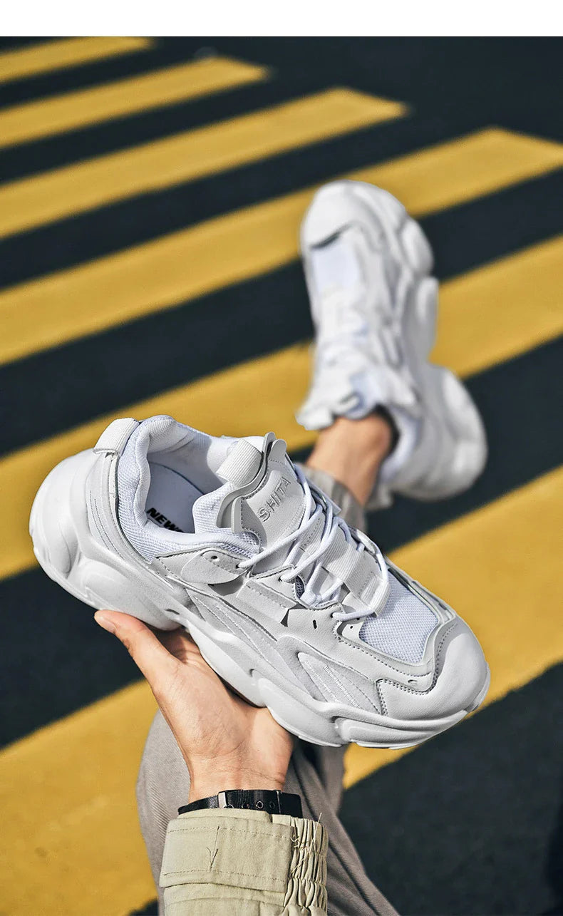 Pair of white, black, and gray casual sports sneakers with leather upper and rubber sole