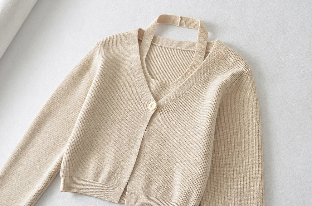 Stylish knitwear vest in a classic black or neutral colour, featuring a V-neck collar and long sleeves for a polished, versatile look.