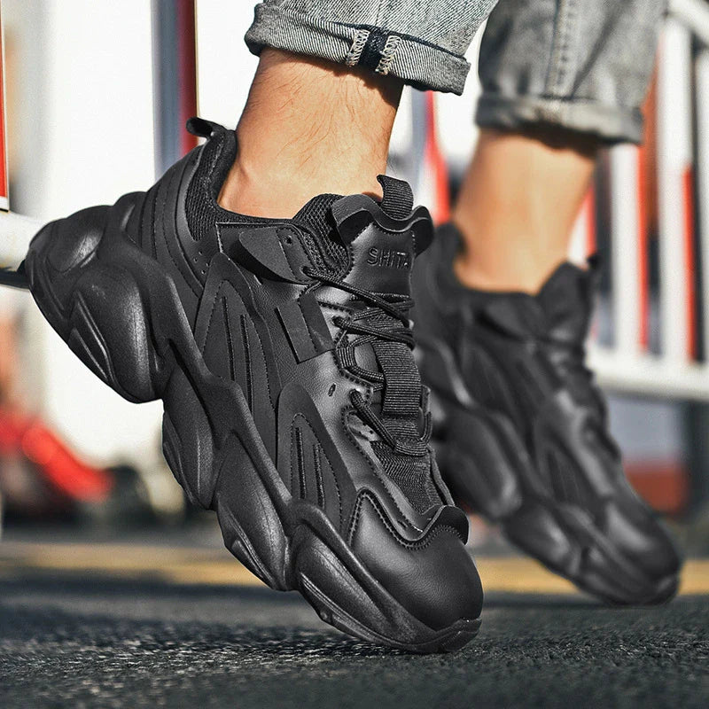 Pair of white, black, and gray casual sports sneakers with leather upper and rubber sole