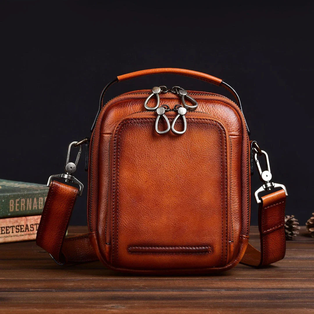 A rugged, retro-inspired cowhide messenger bag made in New Zealand, featuring a spacious interior, multiple pockets, and a comfortable single strap design.