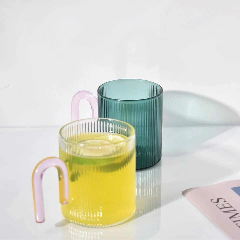 Stylish heat-resistant glass mug with vibrant colourful handle, perfect for hot beverages