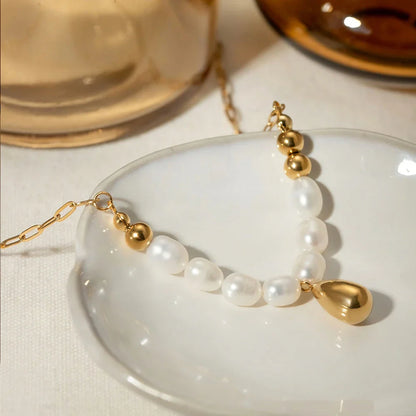 Elegant pearl and gold pendant necklace with a delicate gold drop, a timeless accessory for New Zealanders