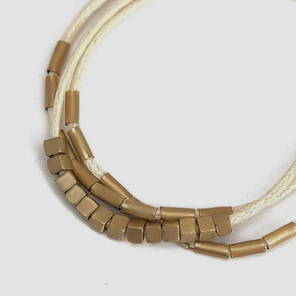 Stylish multilayered bracelet with beige leather and gold-coloured beads, a versatile and modern accessory for Kiwi fashion enthusiasts