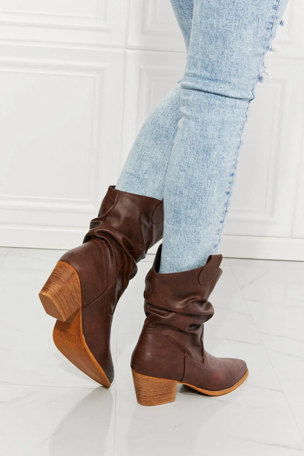 A pair of brown scrunch cowboy boots with a wooden sole, showcasing a sophisticated and stylish design perfect for Kiwi fashion.