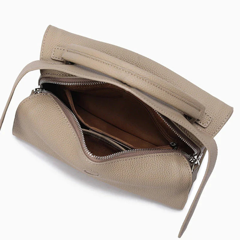 Premium cowhide leather crossbody bag with a unique pillow-shaped design, multiple interior pockets, and an adjustable strap for comfortable everyday wear.