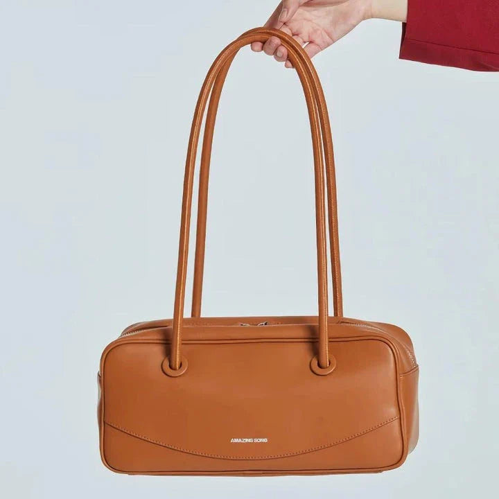 Premium split leather shoulder bag in a baguette shape with a smiley face design, perfect for Kiwis on the go.