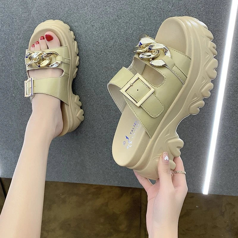 A pair of white, sponge cake-inspired sandals with a metal buckle, showcasing a unique and stylish Kiwi-inspired design.