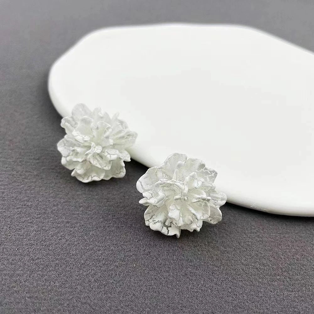 Elegant white floral stud earrings with a timeless design, perfect for adding a touch of sophistication to any Kiwi outfit.