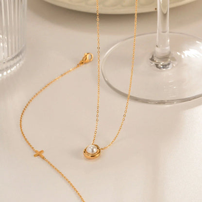 Elegant stainless steel necklace with a unique, irregular pearl pendant in a gold color, featuring a contemporary geometric design