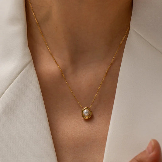 Elegant stainless steel necklace with a unique, irregular pearl pendant in a gold color, featuring a contemporary geometric design