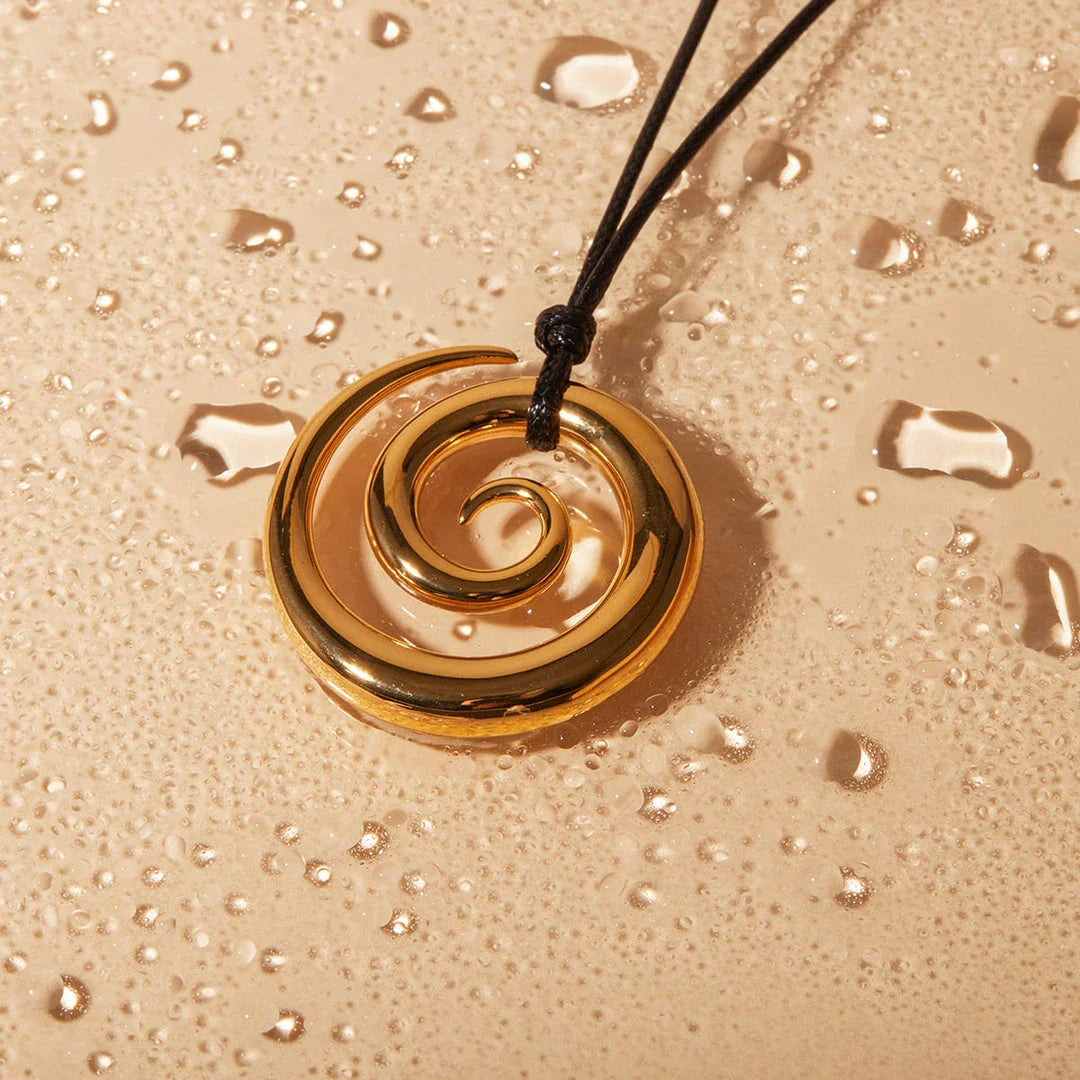 Elegant spiral circle pendant necklace in gold with black rope, a timeless accessory for Kiwi fashionistas