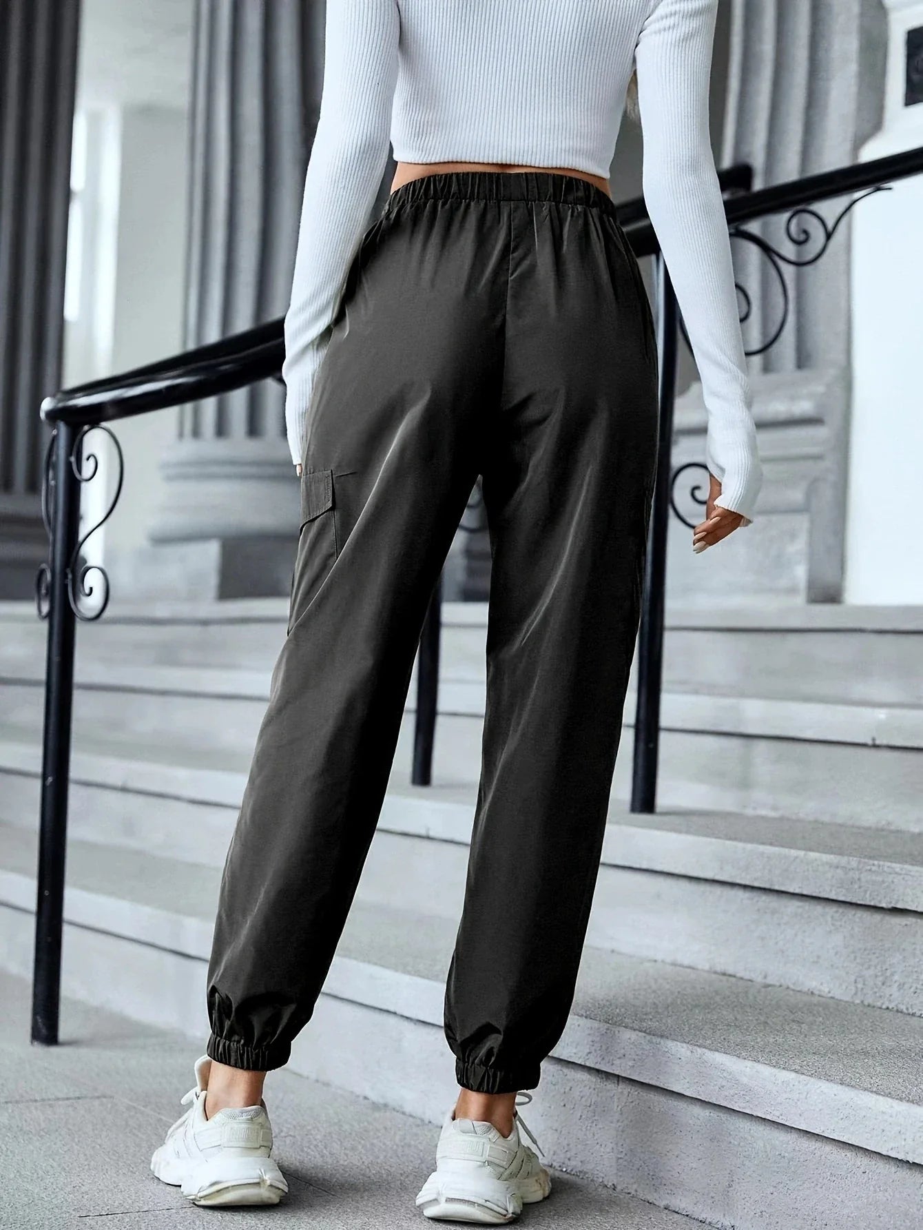 Versatile cargo pants in a black colour, featuring multiple pockets and an elastic waistband for a comfortable, adjustable fit