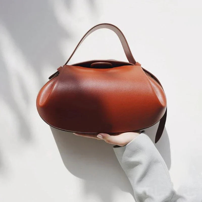 A stylish circular vegan leather handbag with a unique rugby-inspired design, perfect for Kiwi fashion enthusiasts