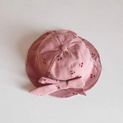 A charming bucket hat for kids featuring a delightful fruit print and cute bow detail, providing excellent sun protection and comfort.