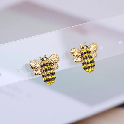 Elegant three-dimensional diamond bee stud earrings in a gold tone, featuring a sparkling design that adds a touch of whimsy and sophistication.