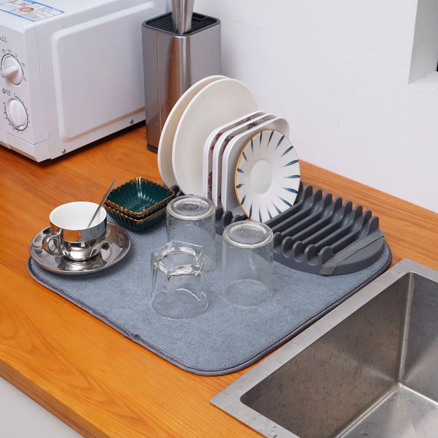 A modern, gray dish drying rack with convenient storage space for kitchen essentials, designed to declutter and streamline your Kiwi kitchen