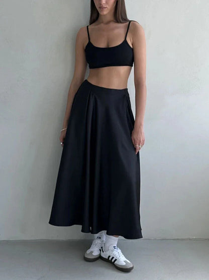 Elegant black satin maxi skirt with flattering empire waistline and ankle-length A-line silhouette, suitable for both formal and casual wear.