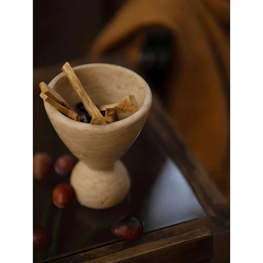 Handcrafted travertine stone incense burner with Palo Santo wood sticks, creating a tranquil atmosphere in a Kiwi-inspired home decor setting