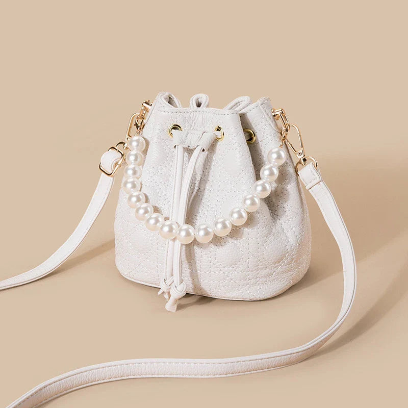 A stylish cowhide bucket handbag in cloud pearl color, featuring a modern design and versatile functionality.