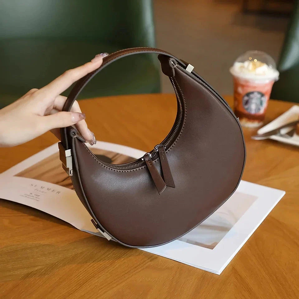 Elegant leather shoulder bag in a half-moon shape, perfect for Kiwi fashion