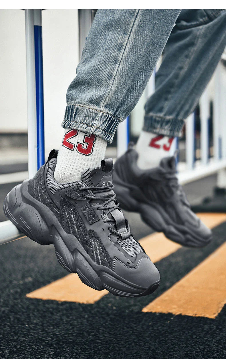 Pair of white, black, and gray casual sports sneakers with leather upper and rubber sole