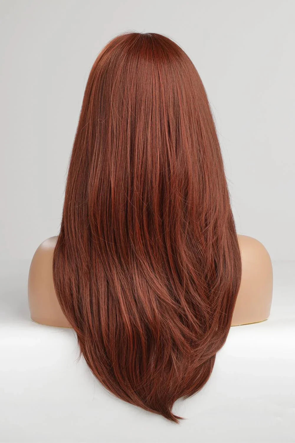 Model wearing a mid-length wave synthetic wig in a vibrant brick color