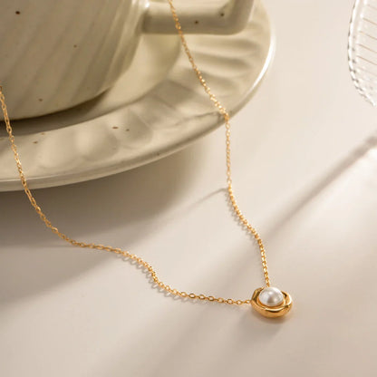 Elegant stainless steel necklace with a unique, irregular pearl pendant in a gold color, featuring a contemporary geometric design