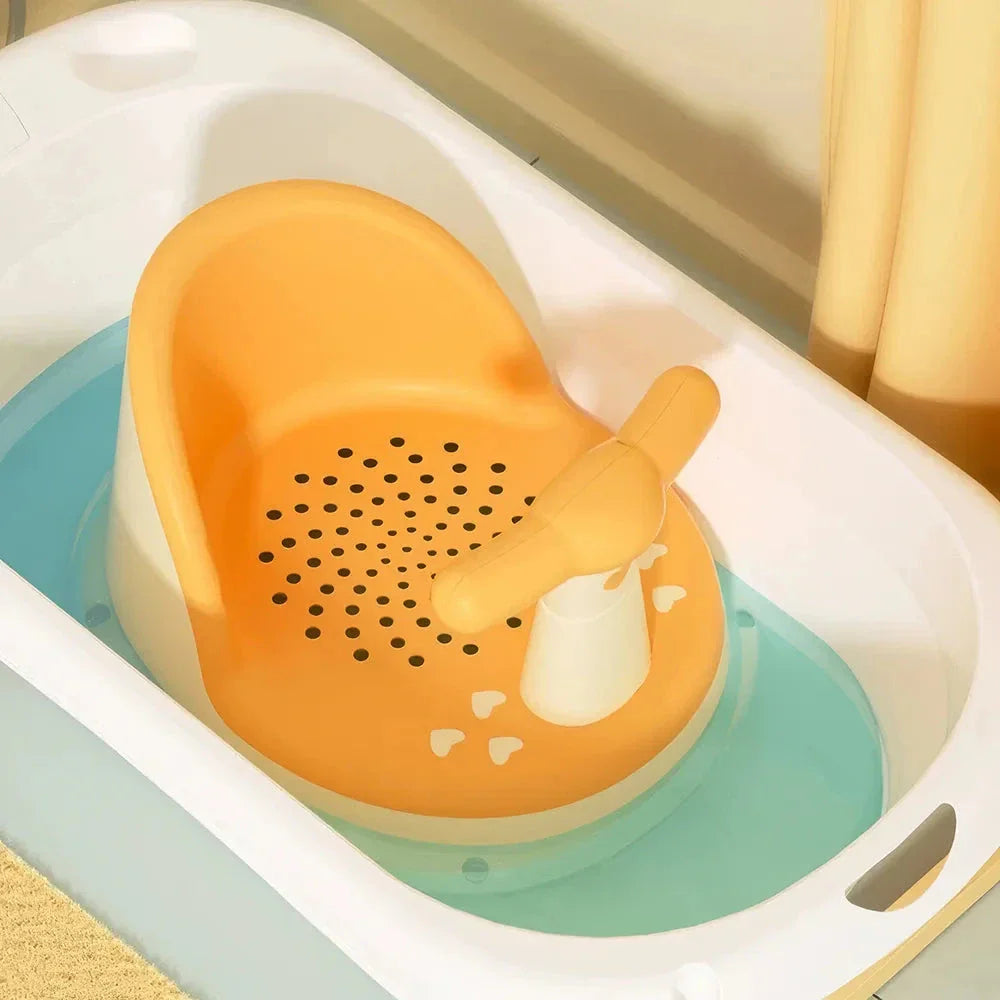 A green, ergonomically designed infant bath tub with large suction cups on the bottom to prevent slipping or tipping.