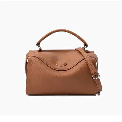 Premium cowhide leather crossbody bag with a unique pillow-shaped design, multiple interior pockets, and an adjustable strap for comfortable everyday wear.