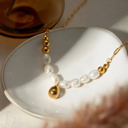 Elegant pearl and gold pendant necklace with a delicate gold drop, a timeless accessory for New Zealanders