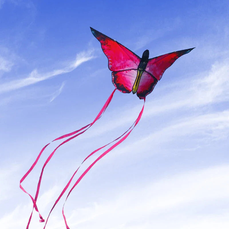 Vibrant red and blue butterfly kite soaring through the skies over New Zealand's scenic landscapes