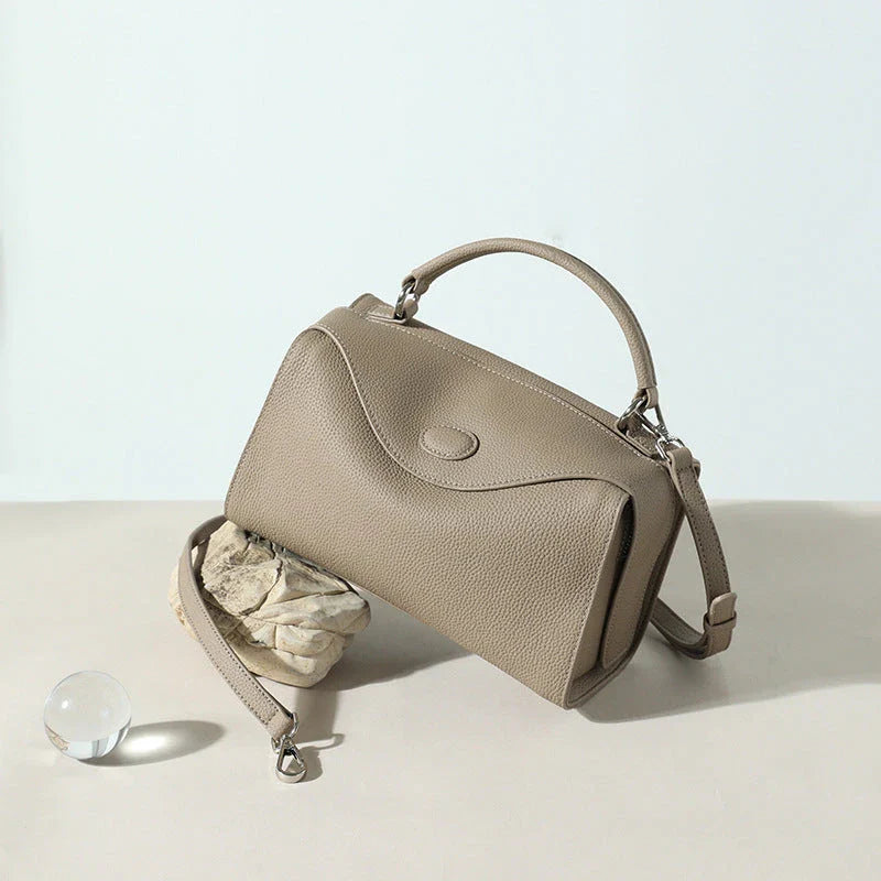 Premium cowhide leather crossbody bag with a unique pillow-shaped design, multiple interior pockets, and an adjustable strap for comfortable everyday wear.