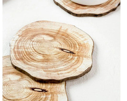 Set of 6 natural timber coasters in various grain patterns, protecting a mug on a wooden surface