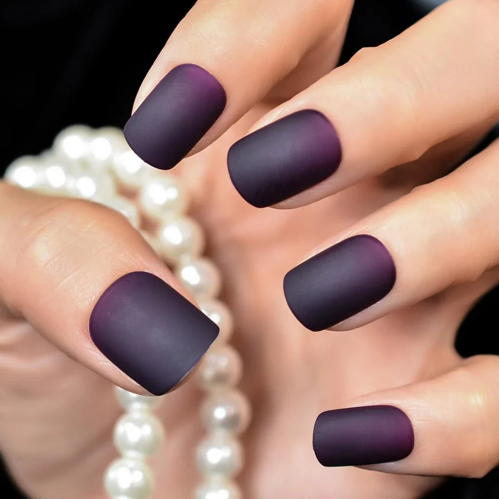 Matte purple and black squoval fake nails with a sleek, salon-quality design