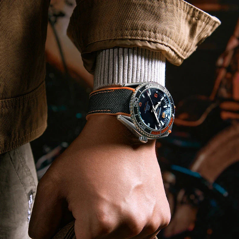 Stylish silver mechanical watch with luminous hands and indices, transparent bottom, and orange accent circle