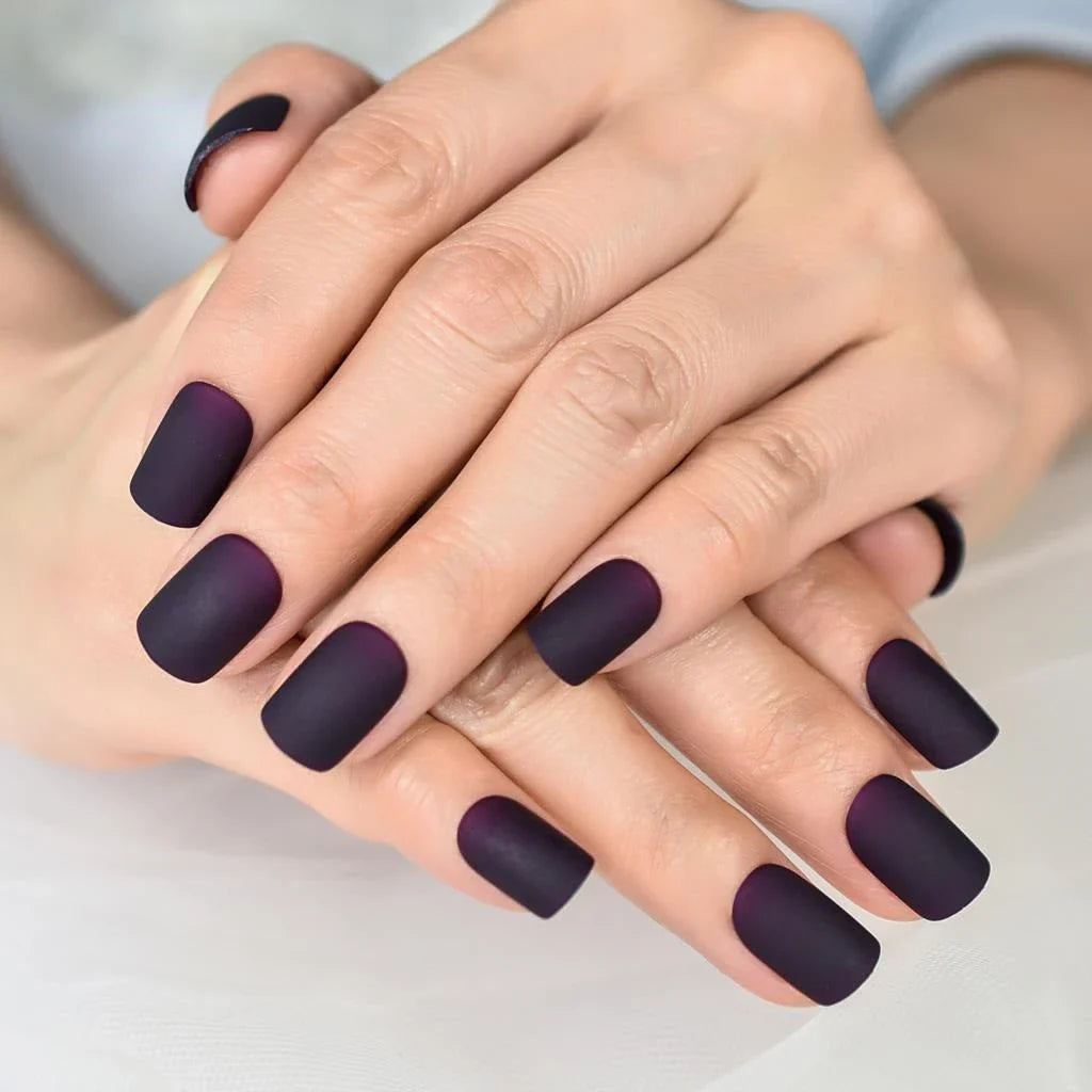 Matte purple and black squoval fake nails with a sleek, salon-quality design