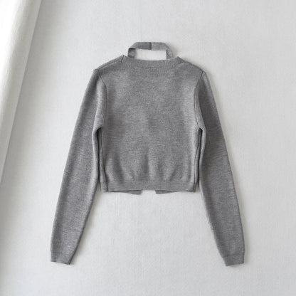 Stylish knitwear vest in a classic black or neutral colour, featuring a V-neck collar and long sleeves for a polished, versatile look.