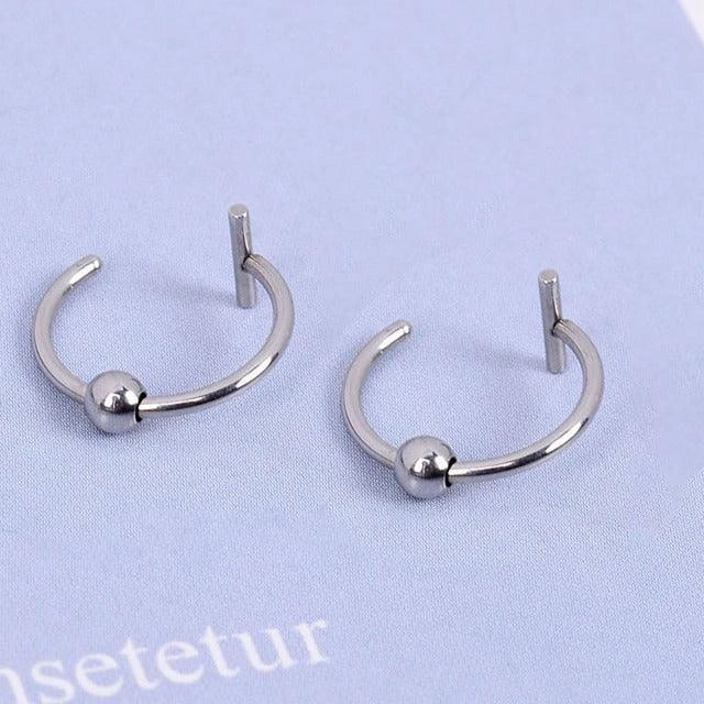 Stylish titanium steel lip rings in gold, silver, and black colors, featuring a unique cuff-style design for a bold, free-spirited look.