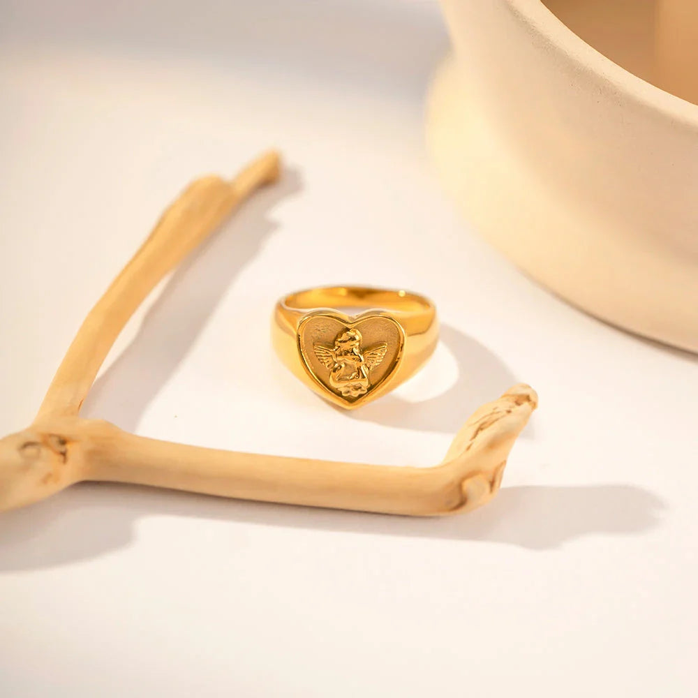 Closeup of a gold plated stainless steel ring with a heart and angel design, a classic and elegant accessory