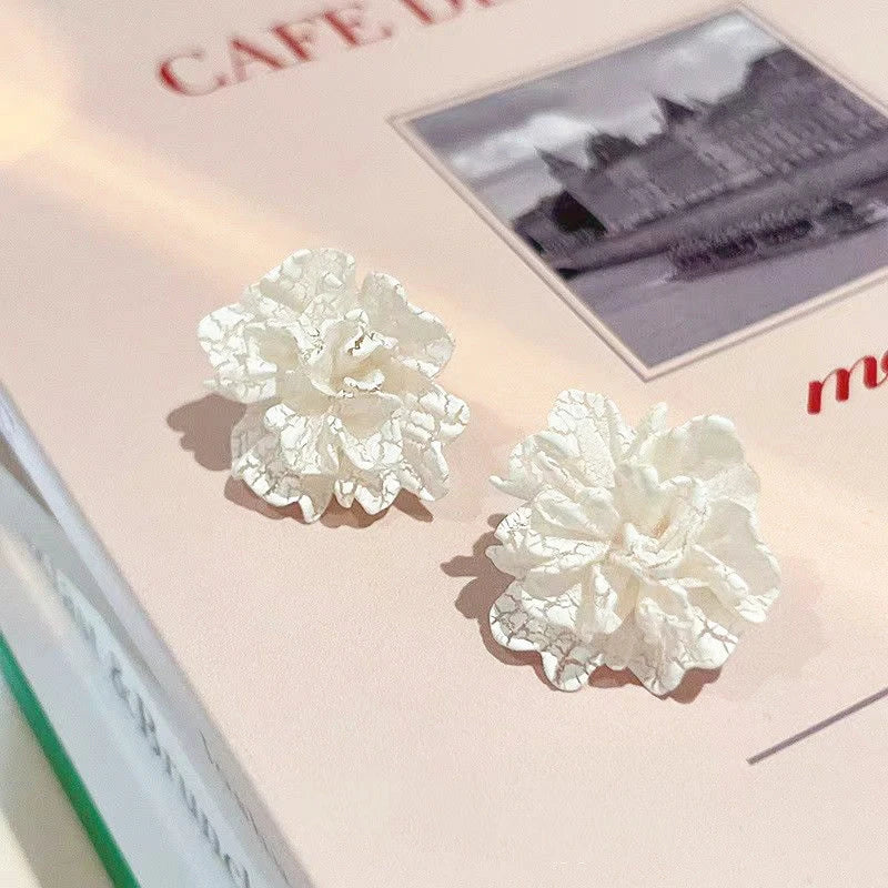 Elegant white floral stud earrings with a timeless design, perfect for adding a touch of sophistication to any Kiwi outfit.