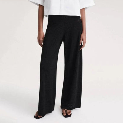 High-waist hollow-out knit trousers in a black color, featuring a straight, wide-leg cut and a sophisticated pattern