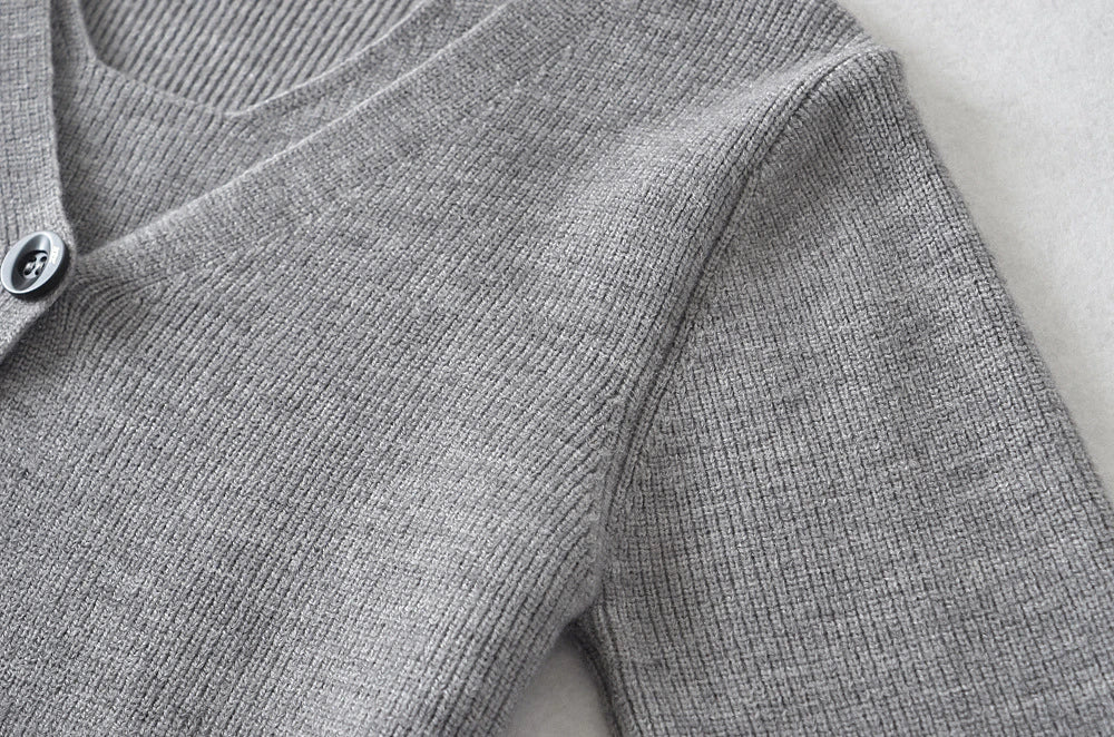 Stylish knitwear vest in a classic black or neutral colour, featuring a V-neck collar and long sleeves for a polished, versatile look.