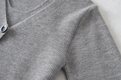 Stylish knitwear vest in a classic black or neutral colour, featuring a V-neck collar and long sleeves for a polished, versatile look.