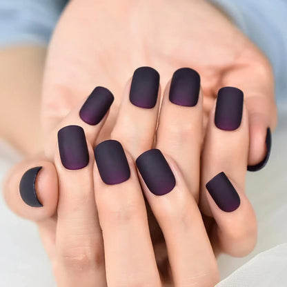 Matte purple and black squoval fake nails with a sleek, salon-quality design