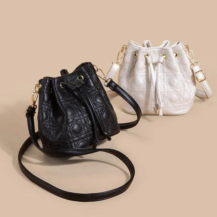 A stylish cowhide bucket handbag in cloud pearl color, featuring a modern design and versatile functionality.