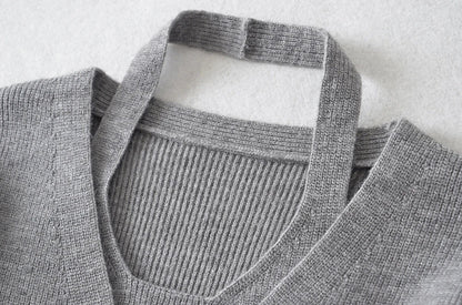 Stylish knitwear vest in a classic black or neutral colour, featuring a V-neck collar and long sleeves for a polished, versatile look.